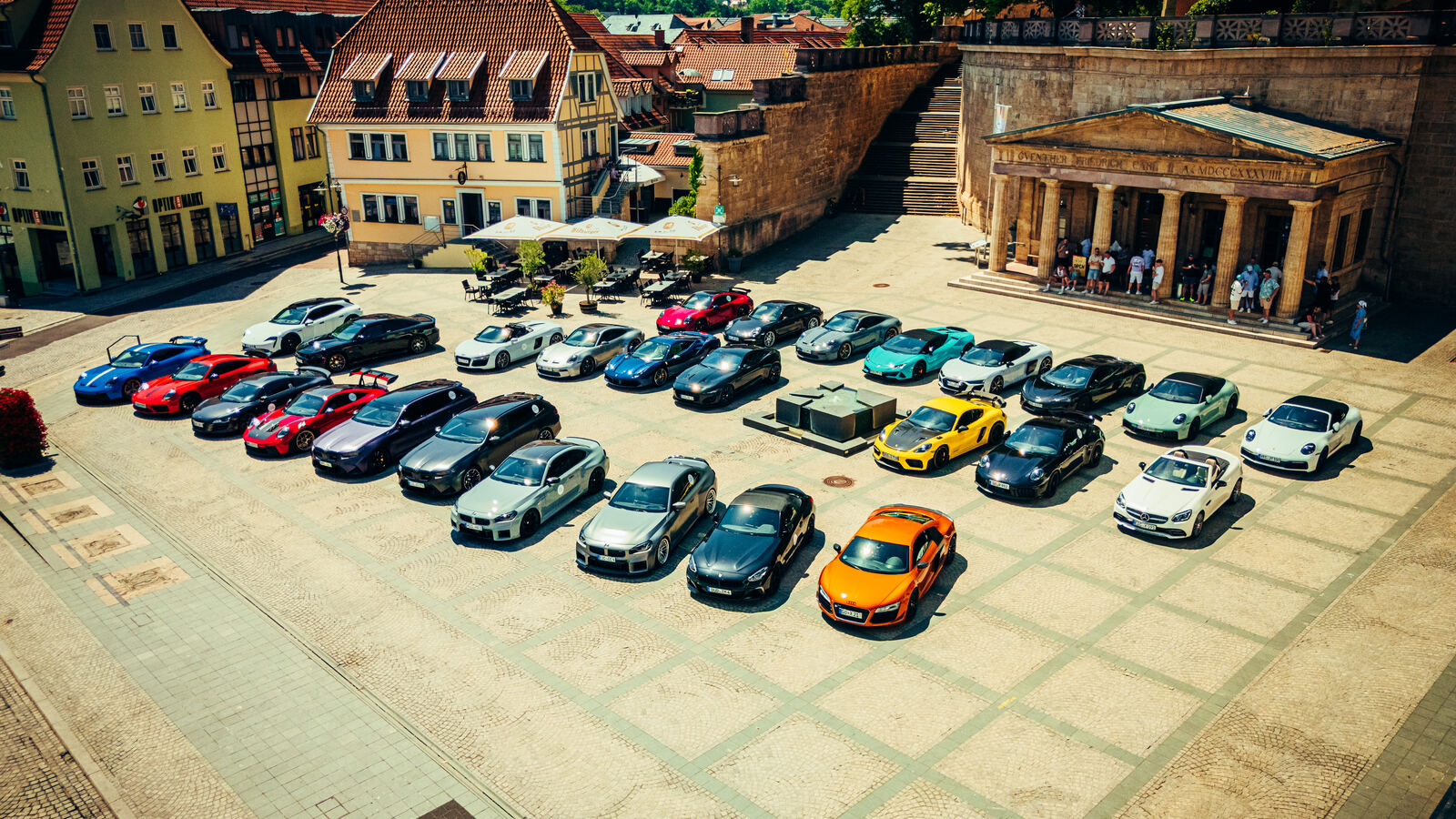 Fahrzeuge des Sportwagen Club Göttingen aufgereiht auf einem historischen Marktplatz während einer gemeinsamen Ausfahrt